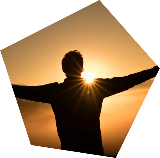 Silhouette with outstretched arms against a sunrise